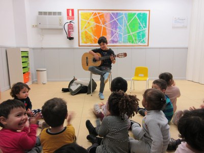 El Guillem toca la guitarra per totes les nenes i nens de l'escola